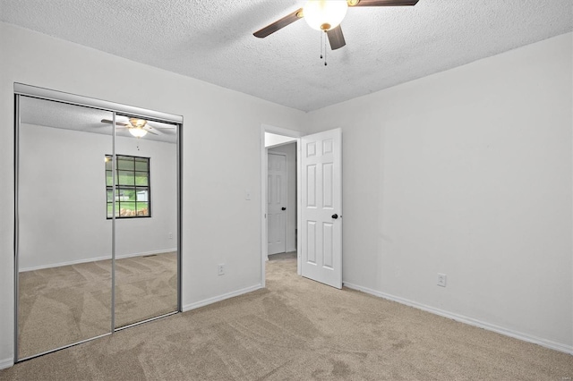 unfurnished bedroom with carpet floors, a textured ceiling, and a closet