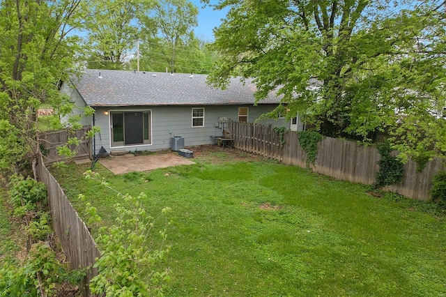 rear view of property featuring roof with shingles, cooling unit, a fenced backyard, a yard, and a patio