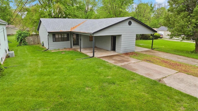 ranch-style home with fence, a front yard, roof with shingles, driveway, and a carport