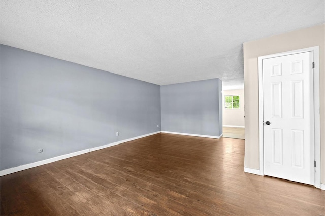 empty room featuring baseboards, a textured ceiling, and wood finished floors