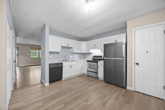 kitchen with a sink, light wood-style floors, stainless steel appliances, and white cabinetry