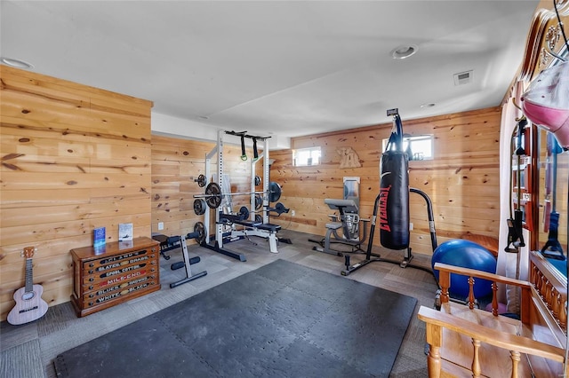 exercise room featuring wood walls and visible vents