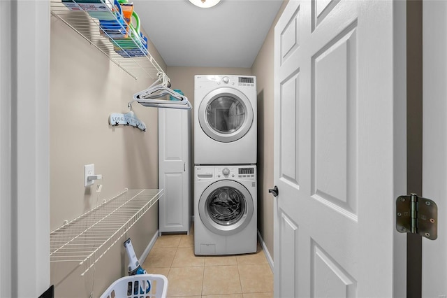 laundry room featuring light tile patterned floors, laundry area, and stacked washer / dryer