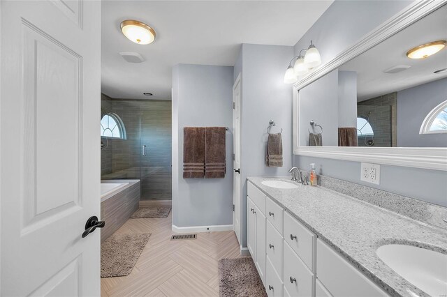 bathroom featuring baseboards, double vanity, a sink, and a shower stall