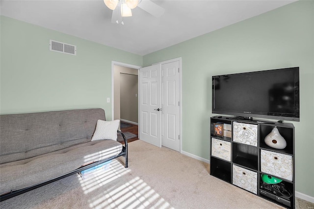 living area featuring ceiling fan, carpet floors, visible vents, and baseboards