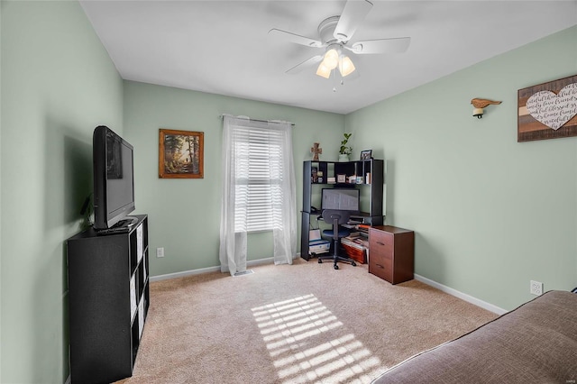 carpeted home office with ceiling fan and baseboards