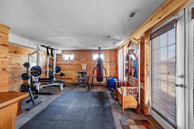 exercise room with wood walls and visible vents