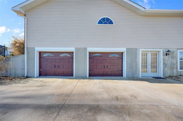 garage featuring concrete driveway and french doors