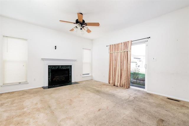 unfurnished living room with carpet, ceiling fan, and a fireplace