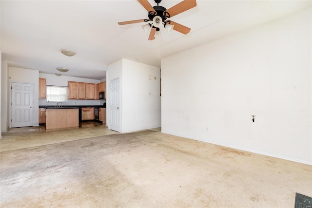 unfurnished living room with ceiling fan and sink