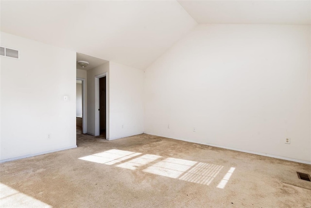 unfurnished room featuring light colored carpet and lofted ceiling