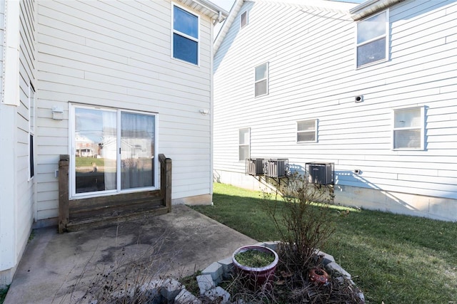 rear view of property with a yard, a patio, and central AC