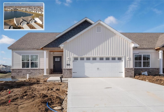 craftsman-style house with a garage and a water view