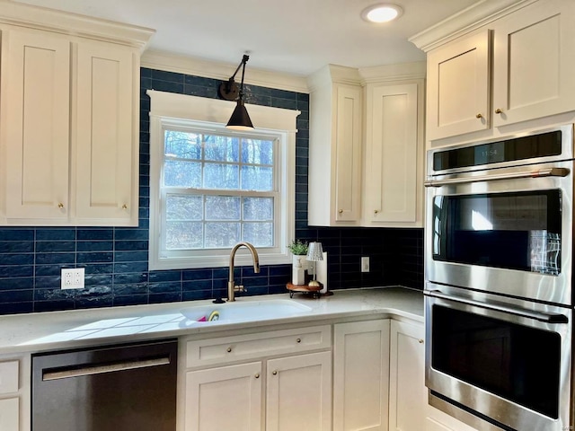 kitchen featuring white cabinets, sink, stainless steel appliances, and tasteful backsplash