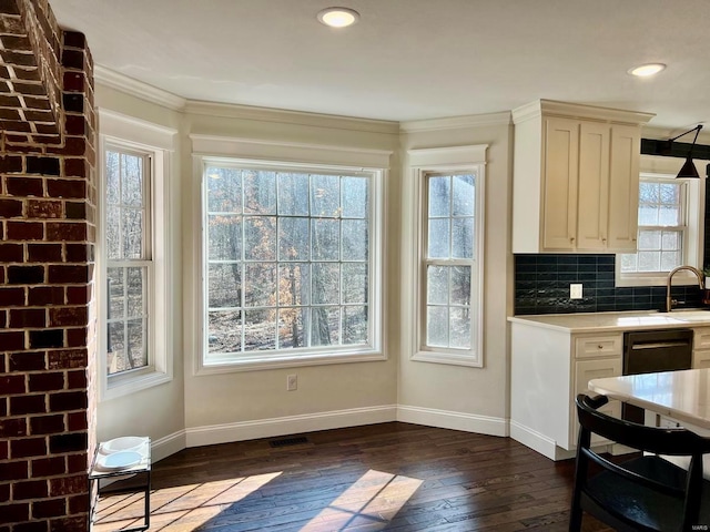 kitchen with tasteful backsplash, black dishwasher, dark wood-type flooring, and ornamental molding