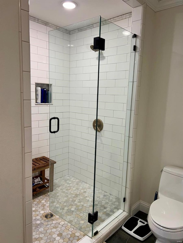 bathroom featuring toilet, tile patterned floors, and a shower with door