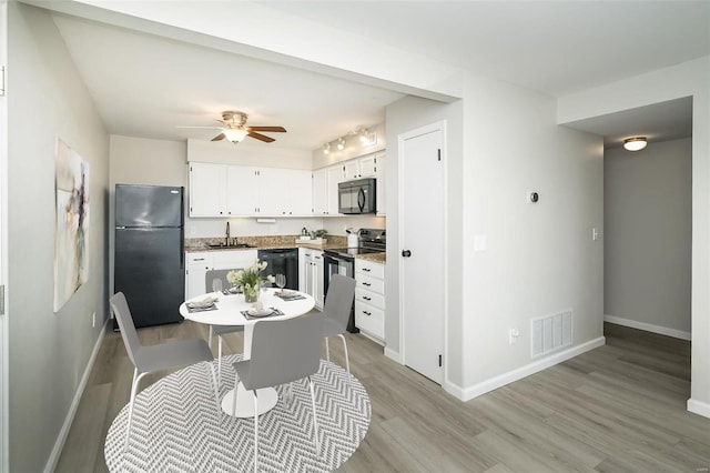 kitchen with sink, white cabinets, ceiling fan, light wood-type flooring, and black appliances