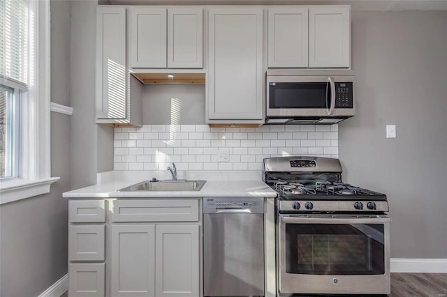 kitchen with white cabinetry, sink, stainless steel appliances, and wood-type flooring