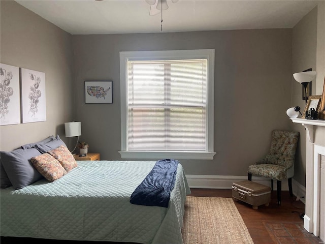 bedroom featuring a tiled fireplace and dark hardwood / wood-style flooring