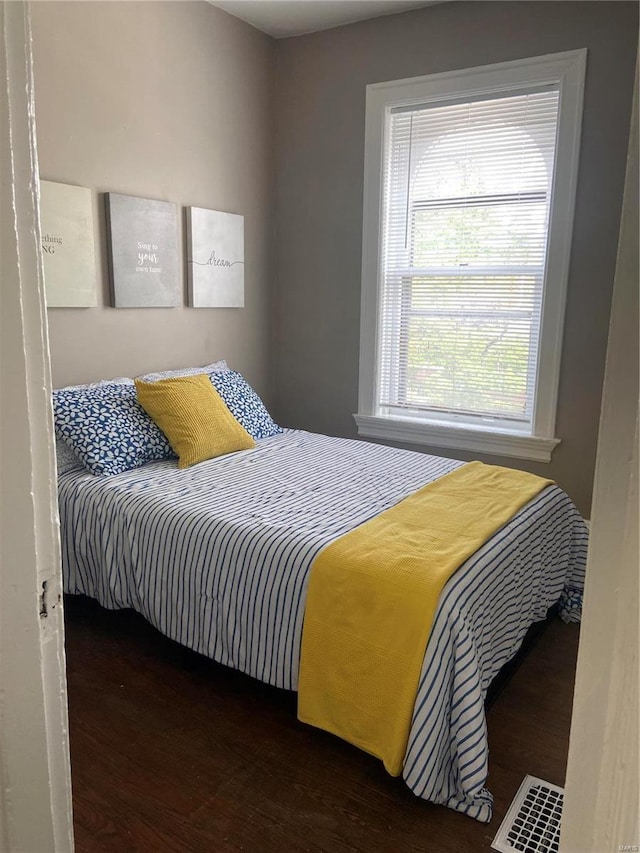 bedroom with dark wood-type flooring and multiple windows