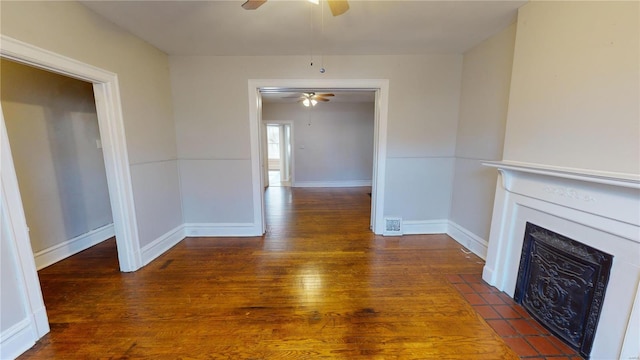 unfurnished living room featuring ceiling fan, dark hardwood / wood-style flooring, and a tile fireplace