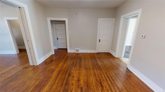 empty room with dark hardwood / wood-style floors