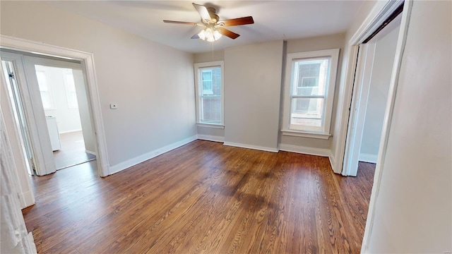 spare room with ceiling fan and dark wood-type flooring