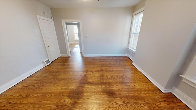 unfurnished room with dark wood-type flooring