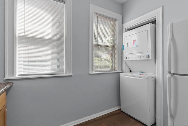 washroom featuring stacked washer / drying machine and dark wood-type flooring