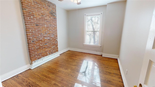 empty room with hardwood / wood-style floors and ceiling fan