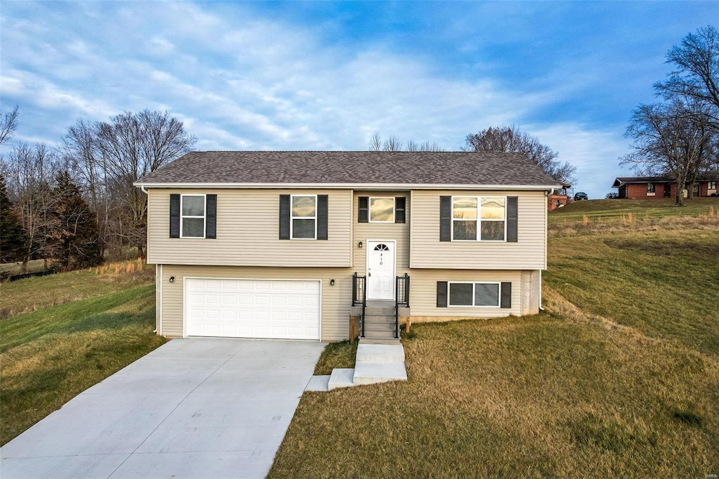 bi-level home featuring a garage and a front lawn