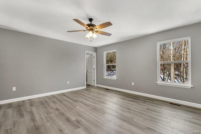 unfurnished room with ceiling fan, plenty of natural light, and hardwood / wood-style flooring