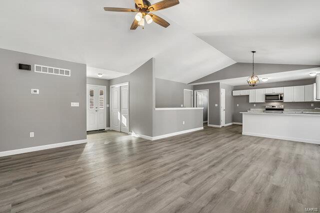 unfurnished living room featuring ceiling fan, hardwood / wood-style floors, and lofted ceiling