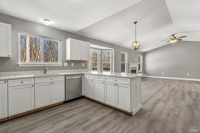 kitchen with ceiling fan, decorative light fixtures, stainless steel dishwasher, sink, and white cabinets