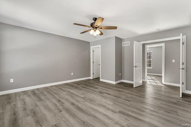 unfurnished bedroom with ceiling fan and wood-type flooring