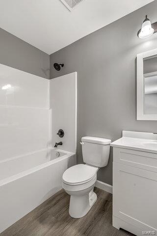 full bathroom with toilet, vanity, shower / tub combination, and hardwood / wood-style floors