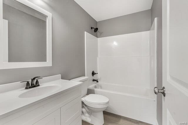 full bathroom with toilet, shower / bathtub combination, hardwood / wood-style flooring, and vanity