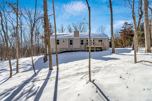 view of snow covered back of property