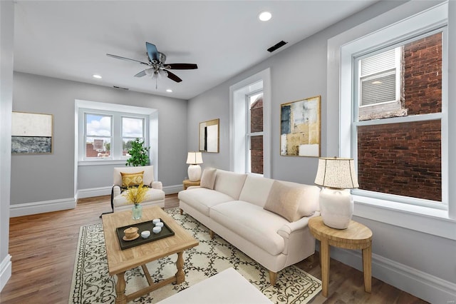 living room featuring hardwood / wood-style floors and ceiling fan