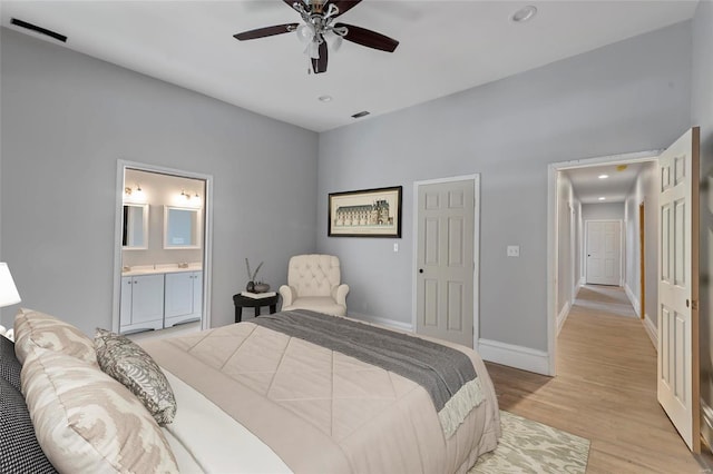 bedroom featuring ceiling fan, light hardwood / wood-style floors, and connected bathroom