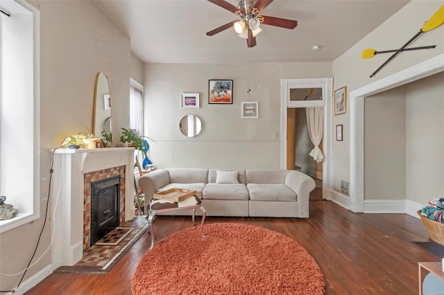 living room with ceiling fan, dark hardwood / wood-style floors, and a brick fireplace