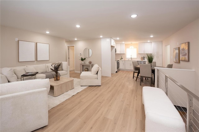 living room featuring sink and light hardwood / wood-style floors