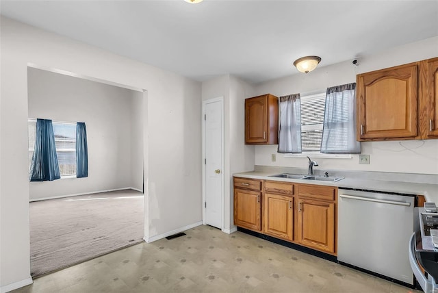 kitchen featuring dishwasher, plenty of natural light, sink, and light carpet