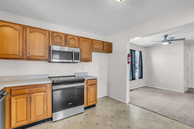 kitchen with ceiling fan, light colored carpet, and stainless steel appliances