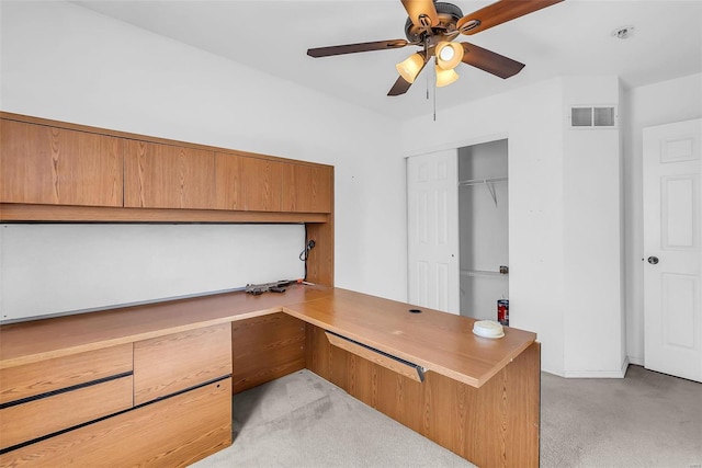 carpeted office space featuring ceiling fan