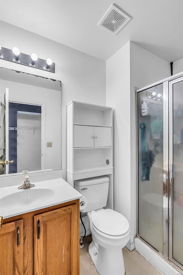 bathroom featuring a shower with door, vanity, and toilet