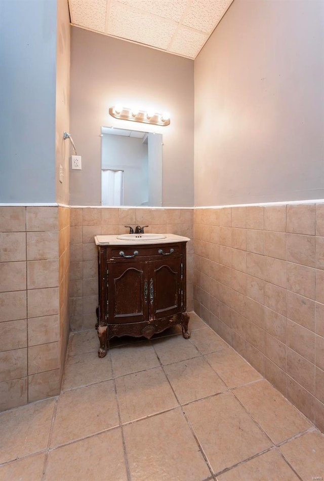 bathroom featuring vanity and tile walls