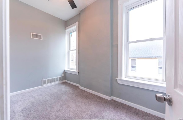 carpeted spare room featuring ceiling fan