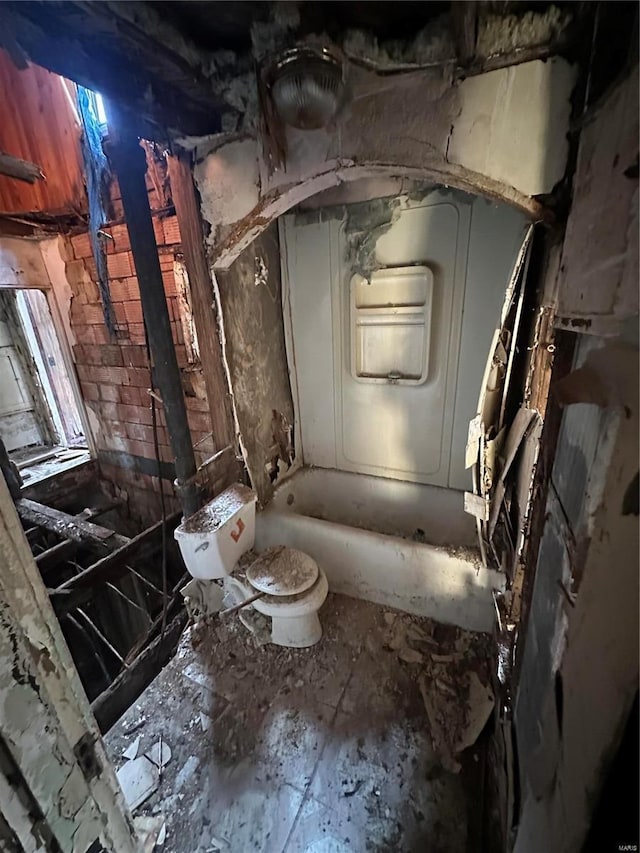 bathroom featuring a washtub and toilet