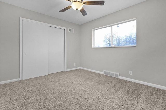 unfurnished bedroom featuring ceiling fan, a closet, and carpet